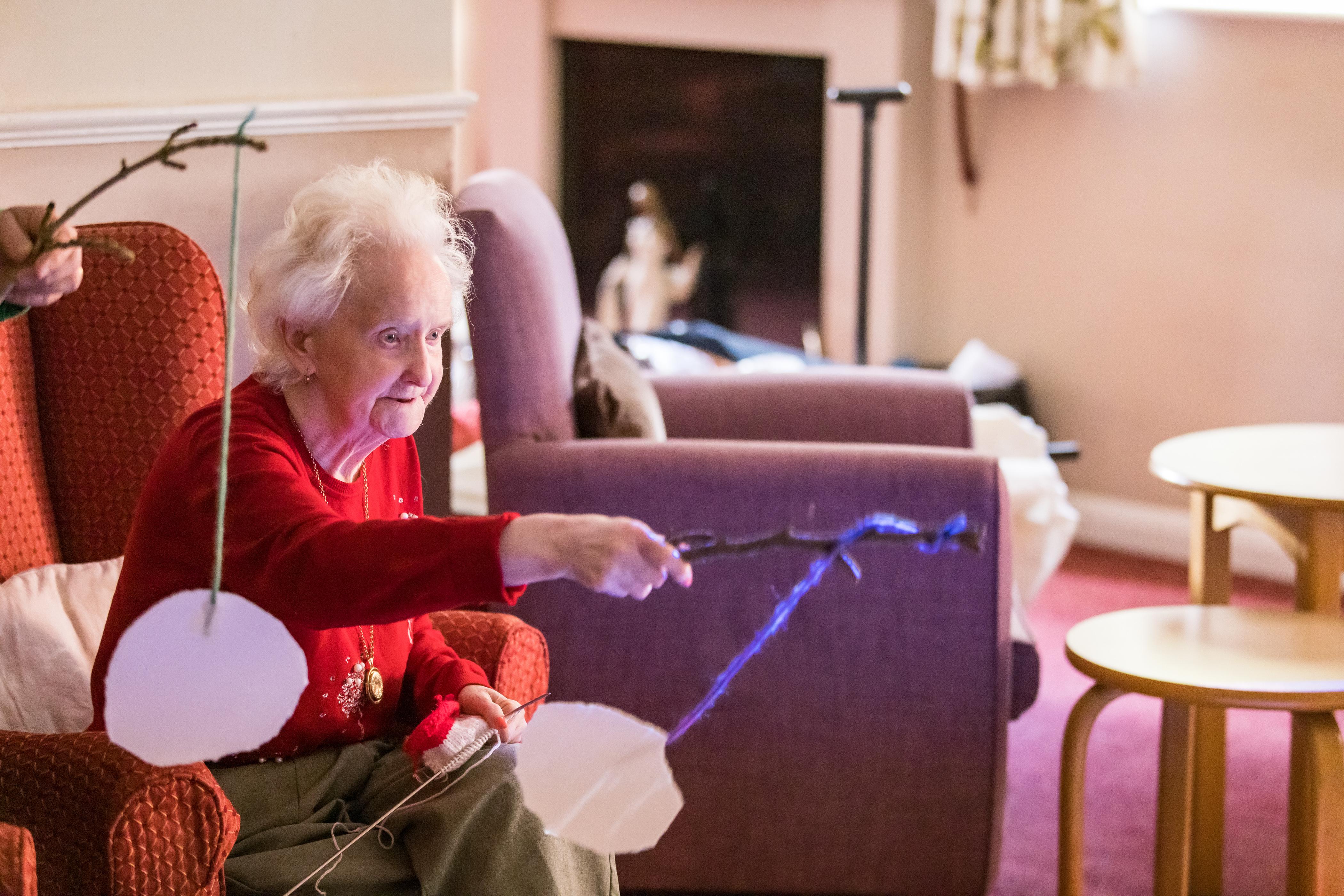 Elderly female sate in a chair in a care home