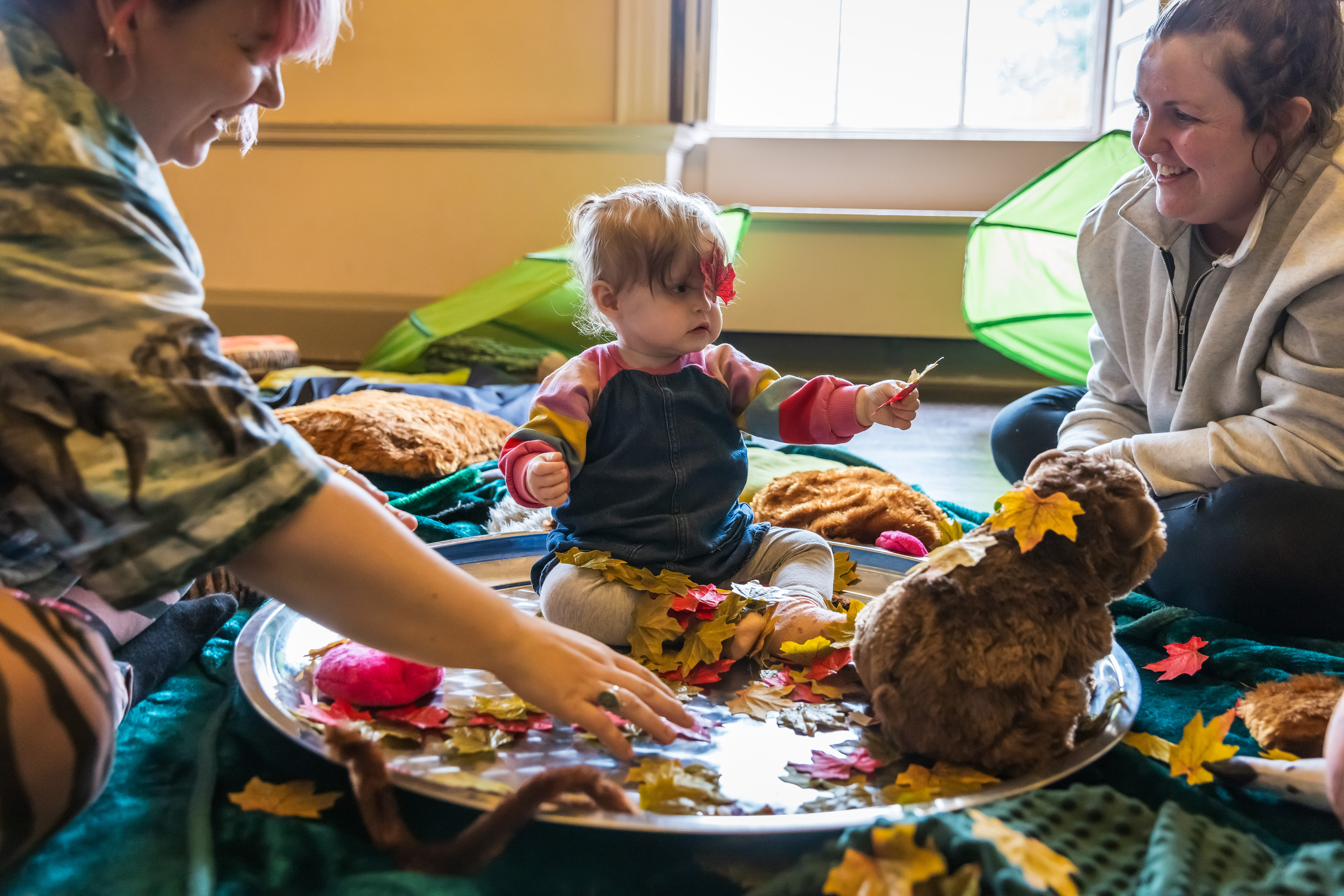 Child sat on the floor playing with toys