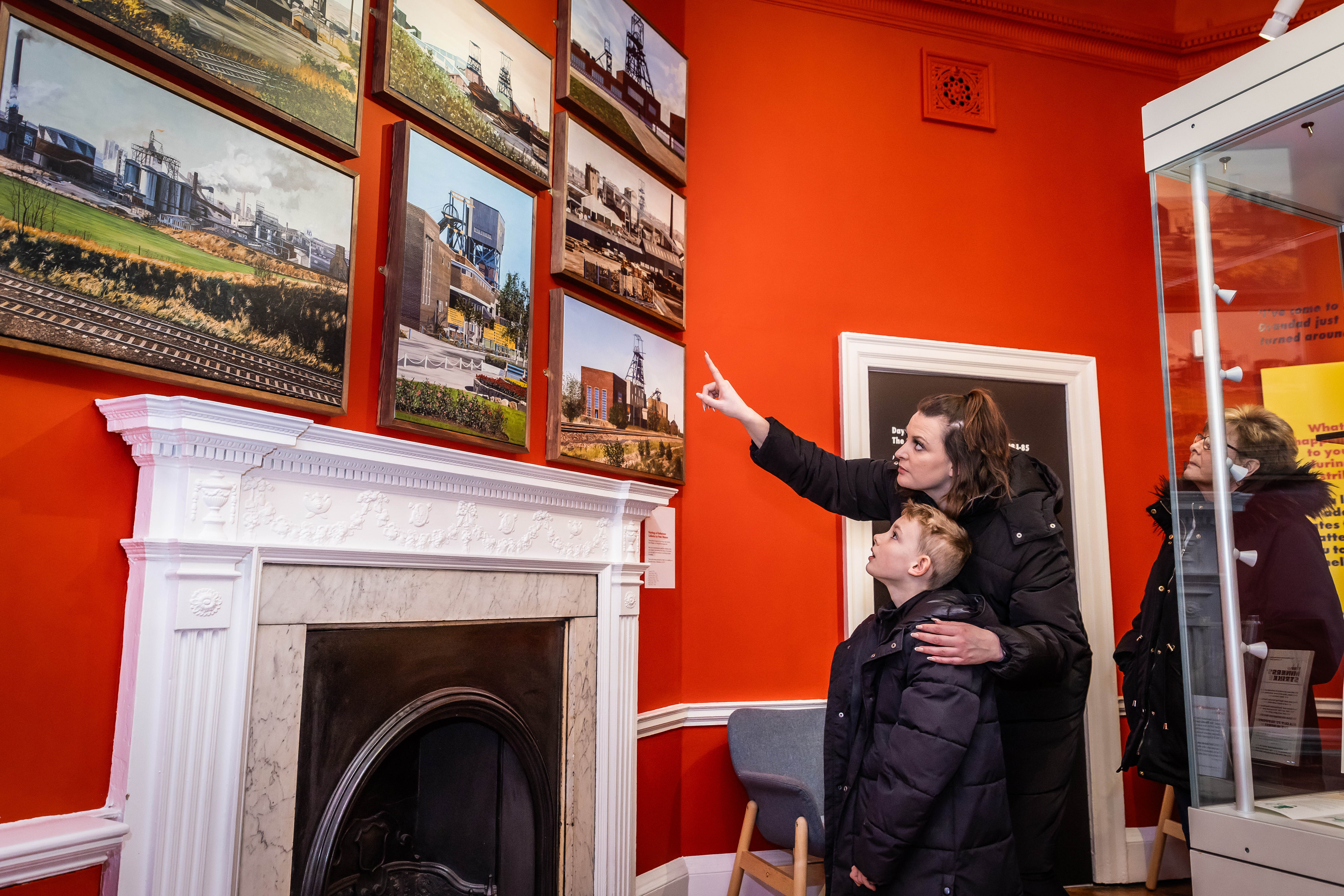 Family pointing to photos in the miners exhibition