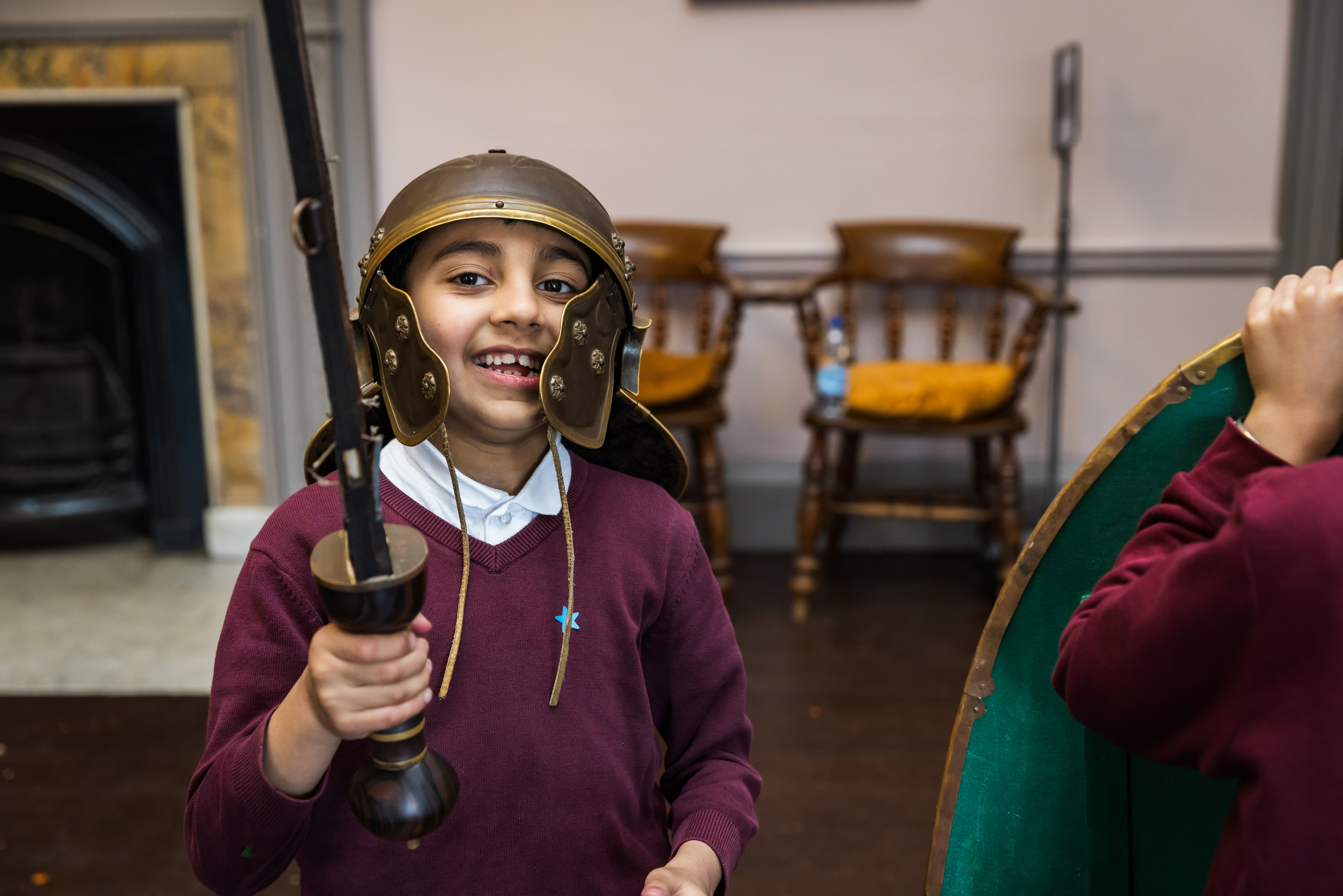 Child wearing a roman helmet and sword