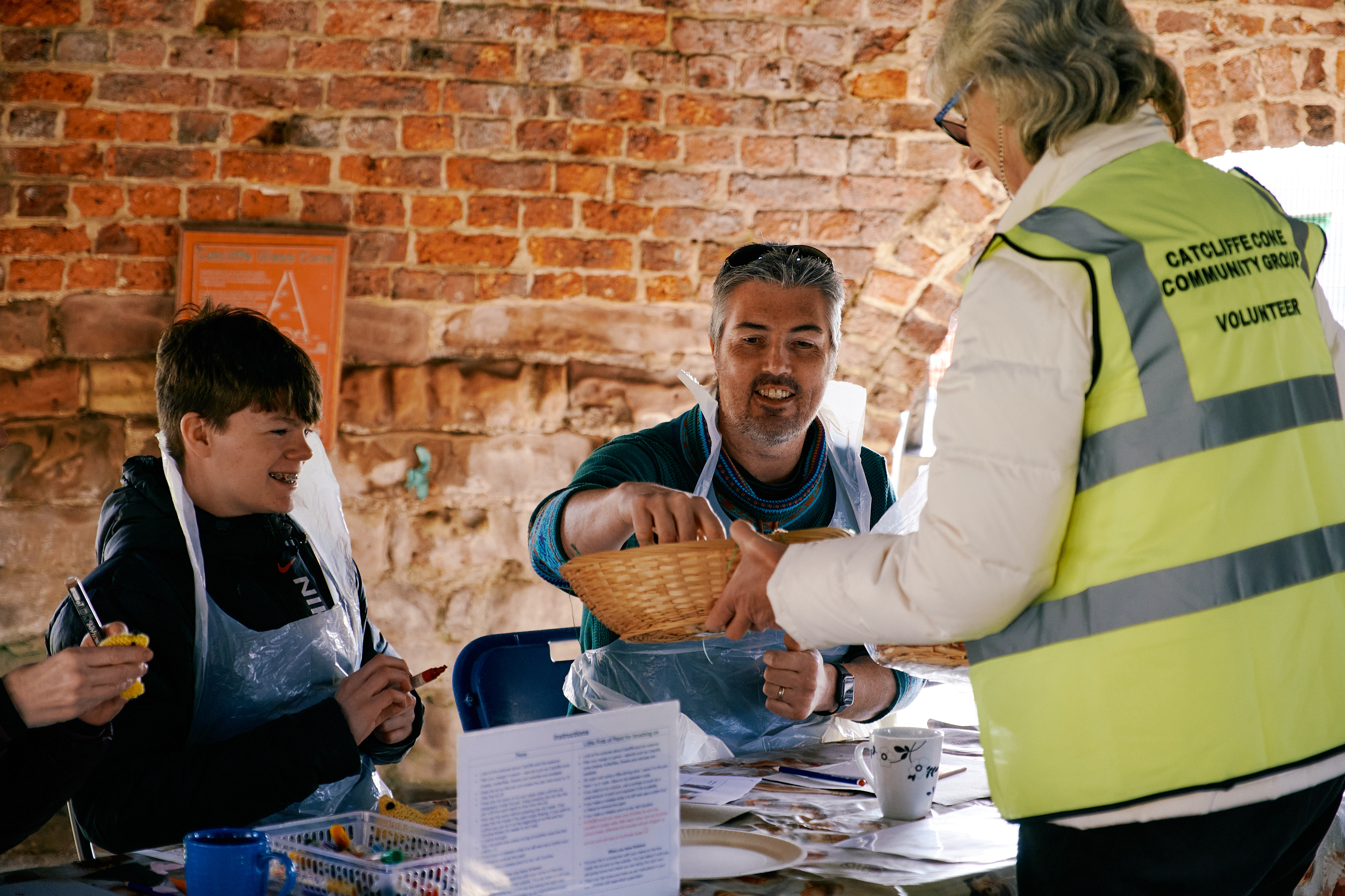 Group sat making crafts inside catcliffe glass cone with a Volunteer