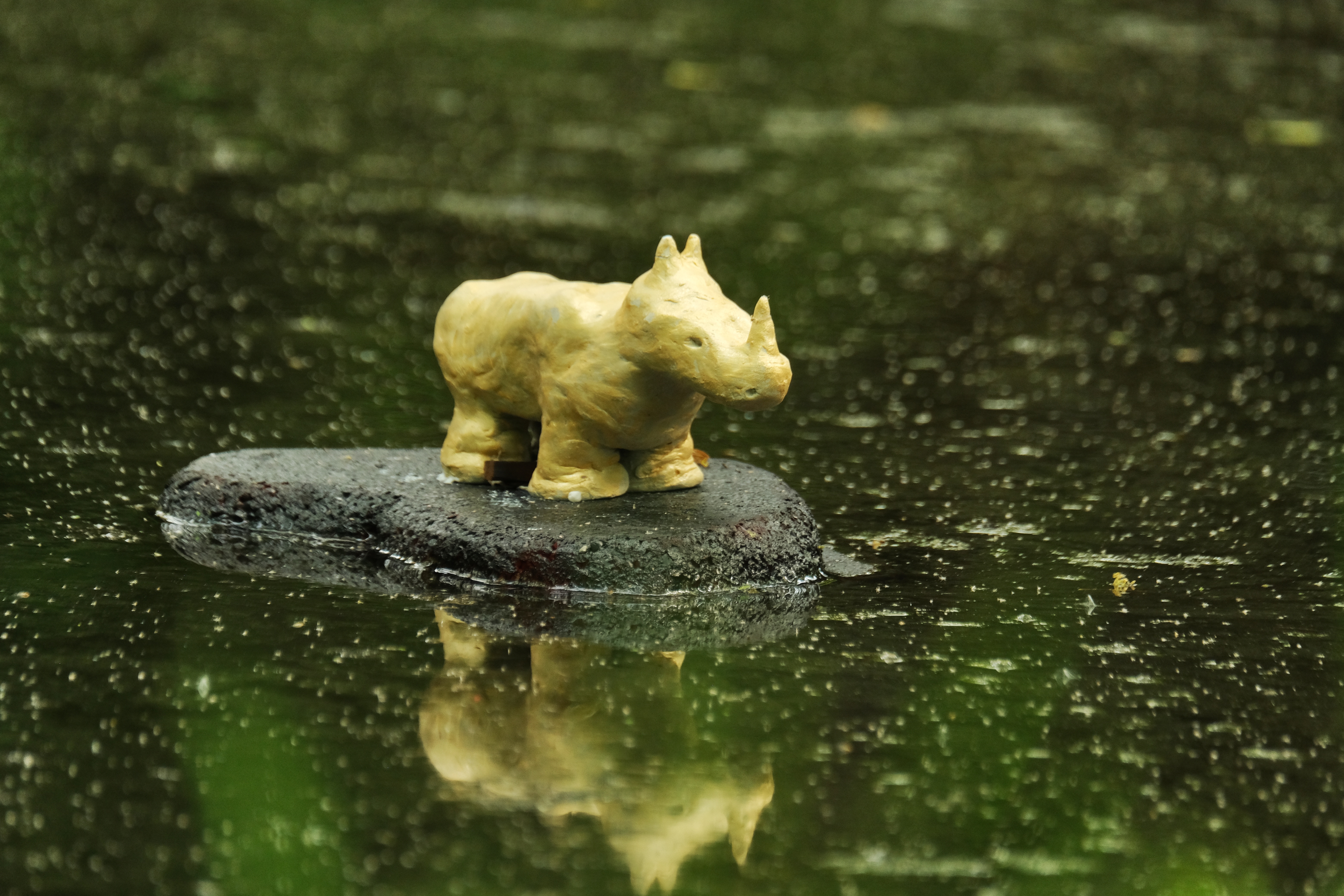 Stone sculpture of a rhino on a rock