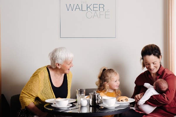 Family enjoying meal with mum holding baby