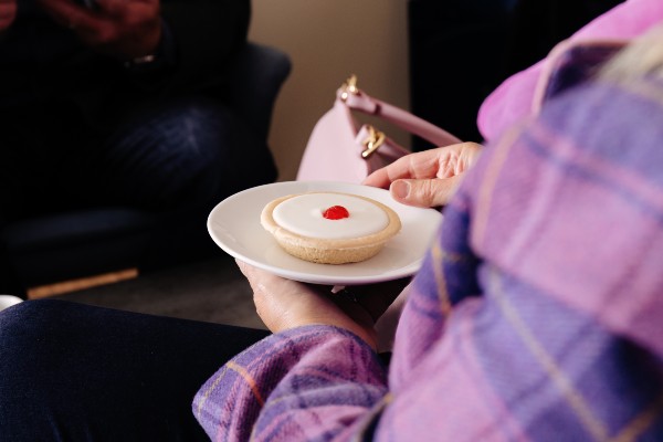 Close up of hands holding cake on a plate