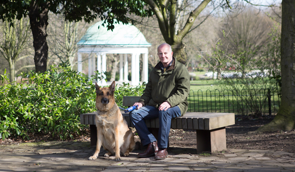 Man sat on bench with dog sat on floor